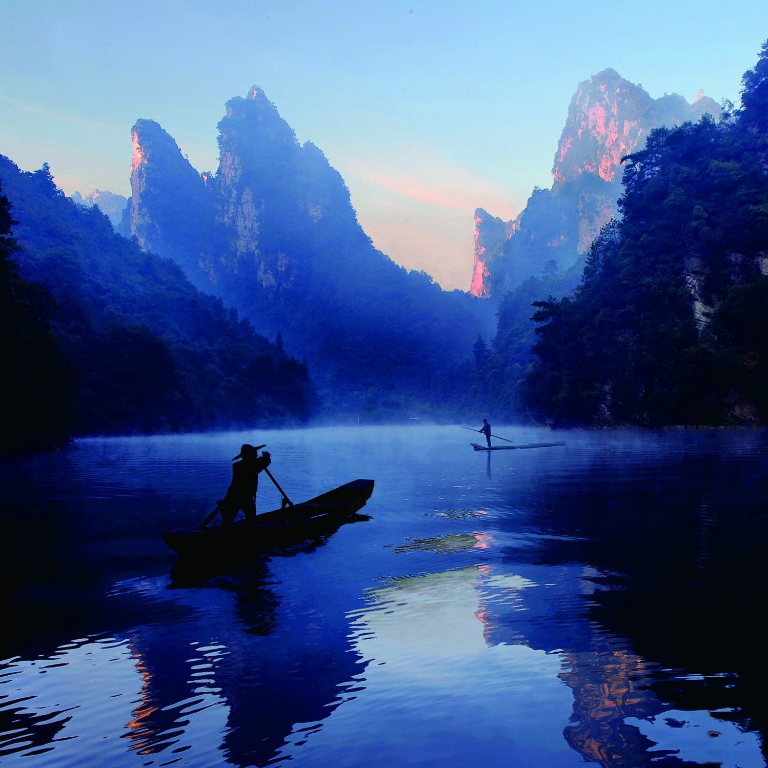 Misty Baofeng Lake with boats and reflected peaks