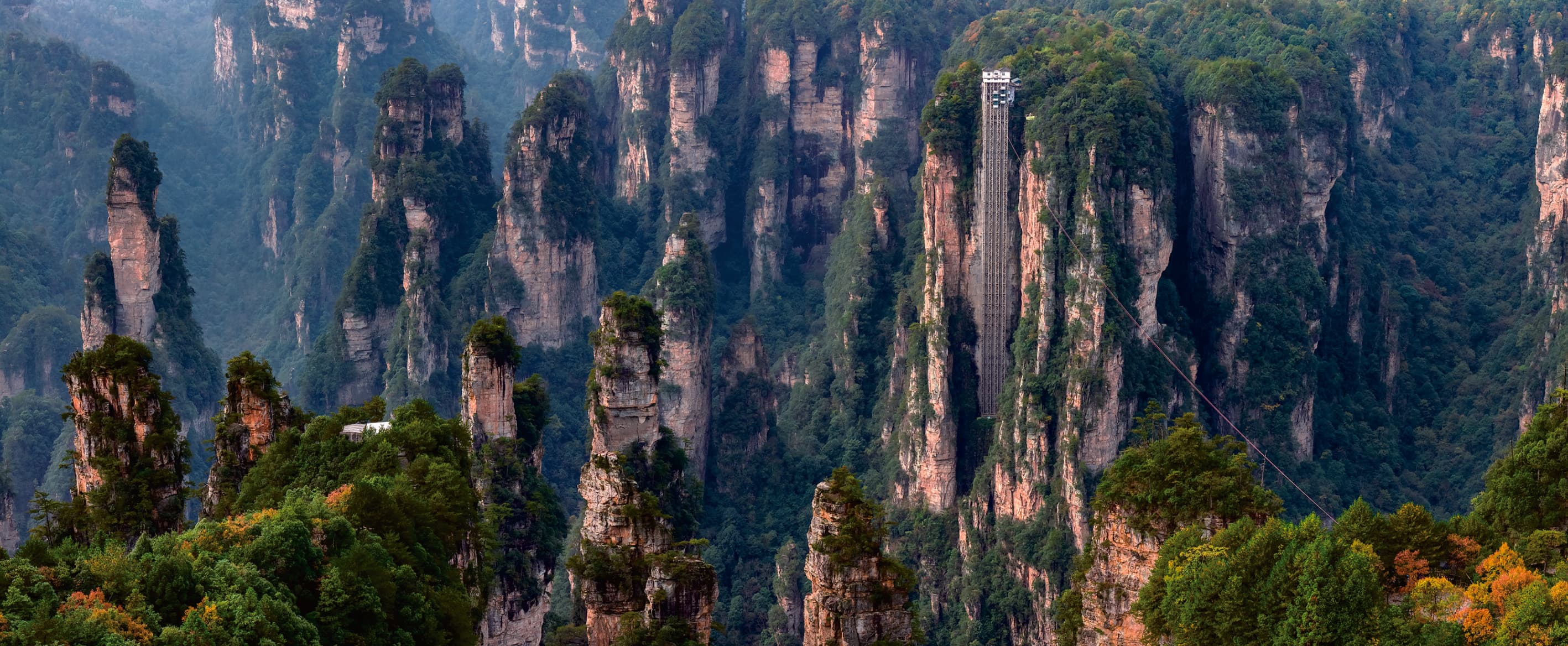 Bailong Elevator rising through the Zhangjiajie sandstone cliffs in the official Tour Guide Manual.