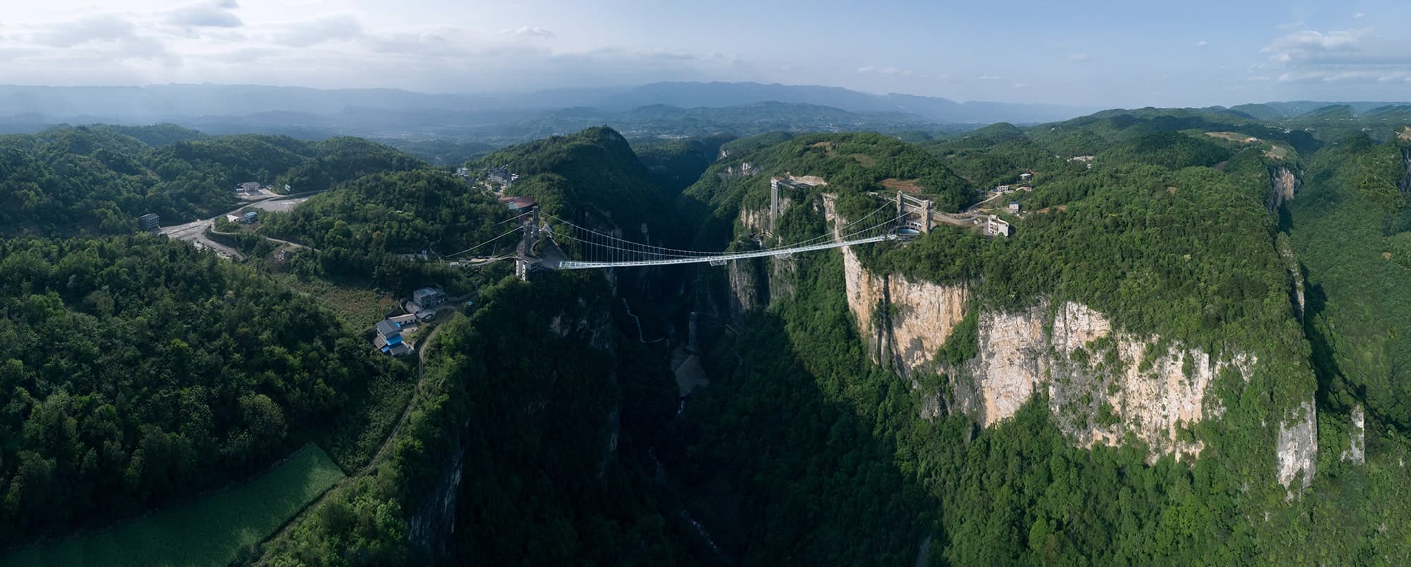 Zhangjiajie Grand Canyon Glass Bridge spanning a forested canyon.