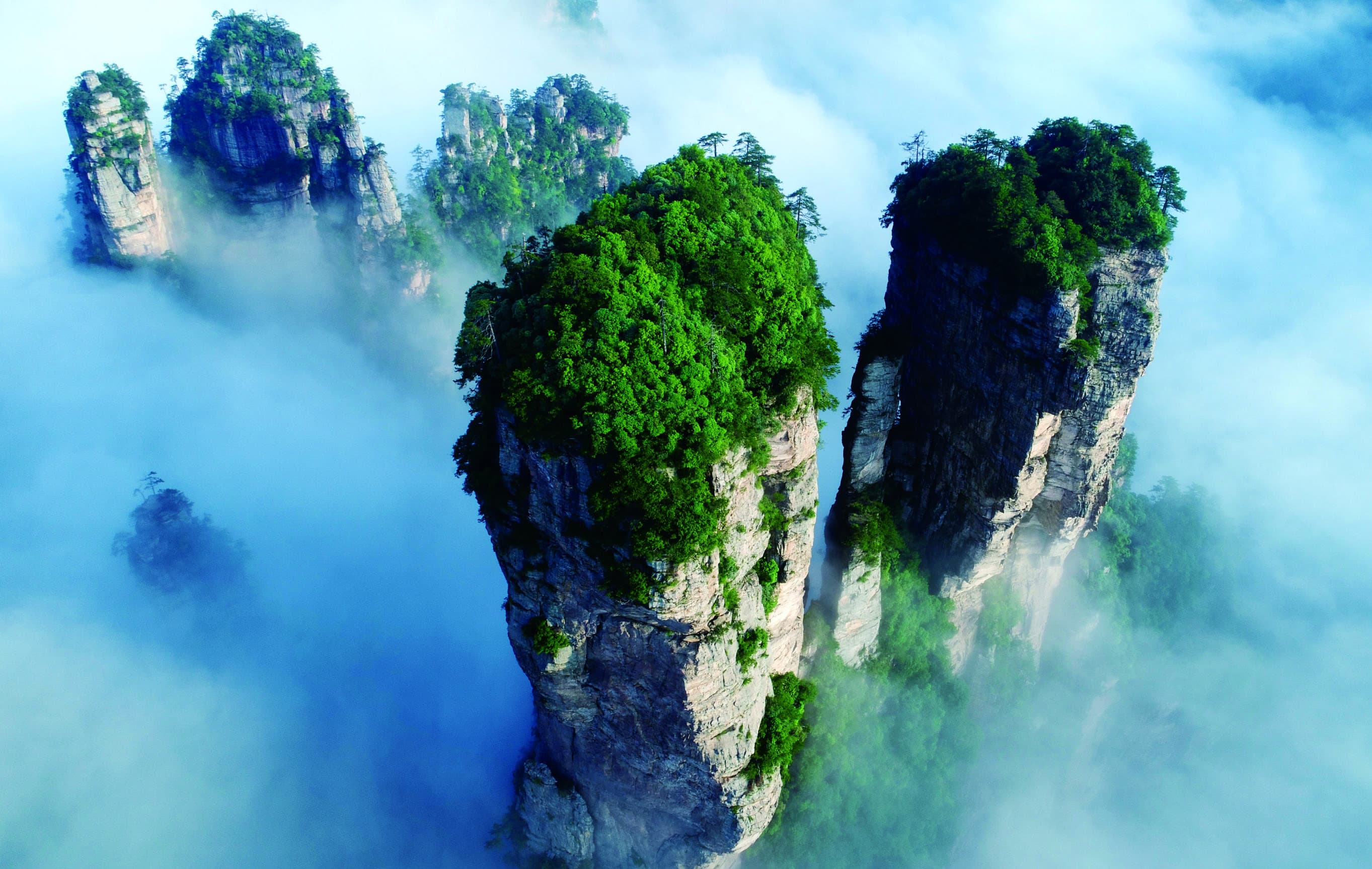 Yuanjiajie sandstone pillars rising through mist in Wulingyuan.